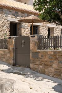 a stone building with a gate and an umbrella at petra apartments apartment No3 in Methoni