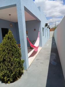 een vrouw in een hangmat in de deuropening van een huis bij Pousada Flor de Caroá in Piranhas