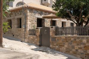 a brick house with a door and an umbrella at petra apartments apartment No3 in Methoni