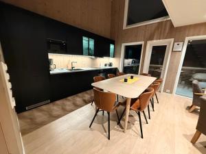 a kitchen and dining room with a table and chairs at Finnvika panorama Cabin 2 in Vestvågøya