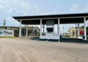 a gas station with a large building in a parking lot at AzHomes AG in Kampong Jelatang