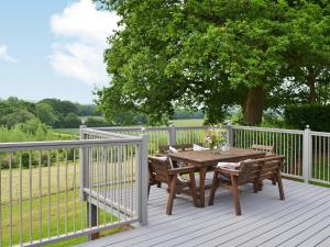 een houten tafel en stoelen op een houten terras bij Wattles-E4527 in Uplowman