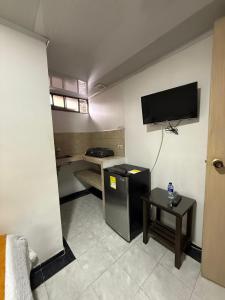 een kleine woonkamer met een televisie en een tafel bij Ayenda Marana in Manizales