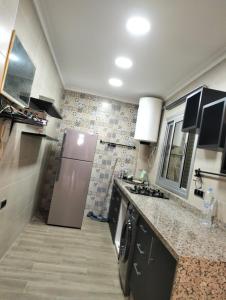 een keuken met een roestvrijstalen koelkast en tegels bij Kitchen sofa tolite And Rome in Sale