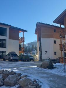 a parking lot with cars parked in front of buildings at Apartment Horalka - Jasná in Belá
