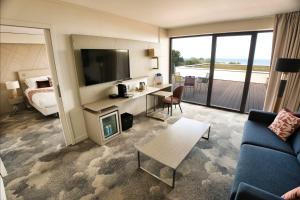 un salon avec un canapé et une chambre avec une télévision dans l'établissement Thalazur Cabourg - Hôtel & Spa, à Cabourg