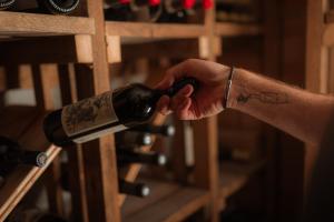 una persona ha in mano una bottiglia di vino di Gfell a Fié allo Sciliar