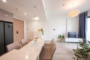 a kitchen and dining room with a white table and chairs at Tommy Land in Gò Công