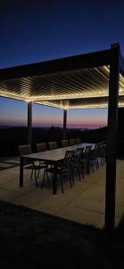 a group of tables and chairs under a roof at Air Cabin A2, A-frame Șerani, Bihor in Şerani