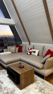 een woonkamer met een bank en een salontafel bij Air Cabin A2, A-frame Șerani, Bihor in Şerani