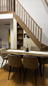 een eetkamer met een tafel en stoelen en een trap bij Air Cabin A2, A-frame Șerani, Bihor in Şerani +10 foto's