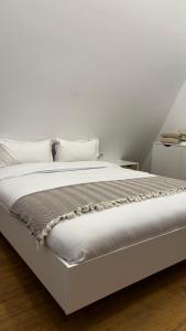 a white bed with white sheets and pillows at Air Cabin A2, A-frame Șerani, Bihor in Şerani