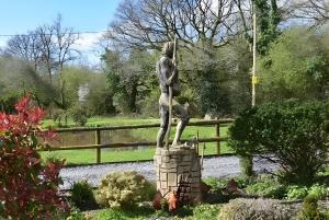 a statue of a person standing on a stone pillar at Ty Llaeth in Llanstephan