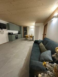 ein Wohnzimmer mit einem blauen Sofa und einem Tisch in der Unterkunft Maison ValGià in Champoluc + 27 Fotos
