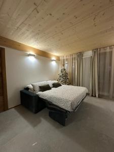 een slaapkamer met een bed en een kerstboom bij Maison ValGià in Champoluc