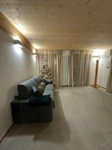 ein Wohnzimmer mit einem Weihnachtsbaum und einer Couch in der Unterkunft Maison ValGià in Champoluc