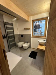 een badkamer met 2 toiletten en een glazen douche bij Maison ValGià in Champoluc