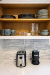 een keuken met een broodrooster en borden op een plank bij Cherry Blossom Lake House in Lake Peekskill