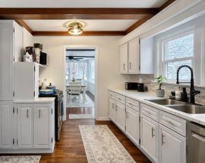 een keuken met witte kasten en een spoelbak bij Cherry Blossom Lake House in Lake Peekskill