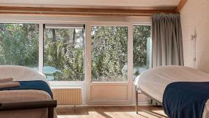 een slaapkamer met twee bedden en een raam bij De Folks in Hoorn