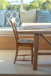 a wooden table with a couch and a wooden chair at Architectural Gem Between Risør And Kragerø in Søndeled +33 photos
