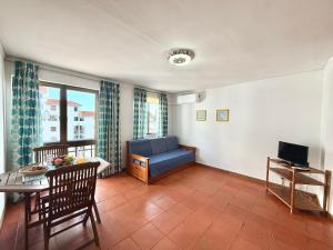 a living room with a blue couch and a table at Algardia Marina Parque by Garvetur in Vilamoura