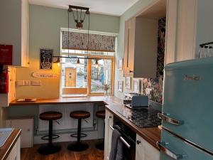 una cucina con un bancone e degli sgabelli di 20 Main Street a Heysham Altre 21 foto