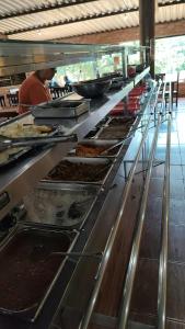a buffet line in a restaurant with people preparing food at Hotel Apis Silvestre in Cruzeiro da Fortaleza