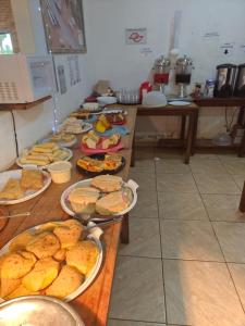 a table with many plates of food on it at Hotel Apis Silvestre in Cruzeiro da Fortaleza