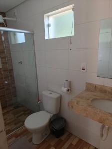 a bathroom with a toilet and a shower and a sink at Hotel Apis Silvestre in Cruzeiro da Fortaleza