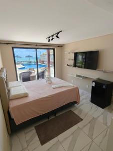 a bedroom with a bed with a view of a pool at Pousada Porto Meu Amor in Porto De Galinhas