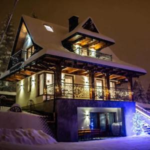 ein Haus im Schnee bei Nacht in der Unterkunft Domek i Apartament pod Tatrami in Suche