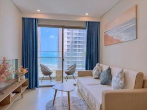 un salon avec un canapé et une grande fenêtre dans l'établissement Habi Home - The Sóng Vũng Tàu, à Vung Tau