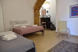 a room with two beds and a chair and a staircase at Meithras Holiday Homes in Agrigento +31 photos