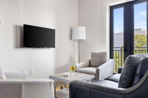 a living room with two chairs and a tv at Fire Tower Classy 1BR in Downtown Charleston in Charleston
