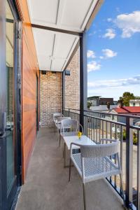 a patio with tables and chairs on a balcony at Fire Tower Classy 1BR in Downtown Charleston in Charleston