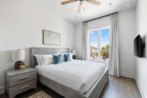 a white bedroom with a large bed and a window at Fire Tower Classy 1BR in Downtown Charleston in Charleston +7 photos