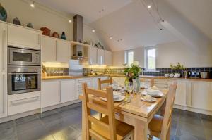 a kitchen with a wooden table and chairs at 3 Bed in Croyde oc-spind in Croyde