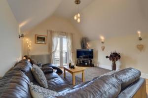 a living room with a leather couch and a tv at 3 Bed in Croyde oc-spind in Croyde