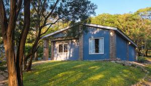 a blue tiny house in the middle of a yard at Flor de Lis Casas de Campo in Los Cocos