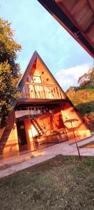 ein großes Holzhaus mit offener Tür in der Unterkunft Chalé Bela Vista in Munhoz