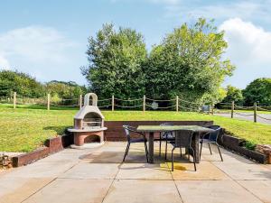 un patio con tavolo, sedie e griglia di Rook a Broadhempston Altre 11 foto