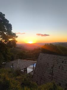 einen Blick auf den Sonnenuntergang von einem Haus aus in der Unterkunft Chalé Bela Vista in Munhoz + 72 Fotos