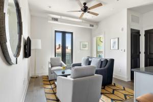a living room with two chairs and a ceiling fan at Fire Tower Downtown Gem 1BR with Balcony & Views in Charleston