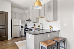 a kitchen with white cabinets and a kitchen island with stools at Fire Tower Downtown Gem 1BR with Balcony & Views in Charleston +7 photos