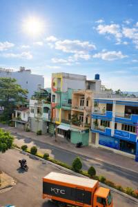 a bus driving down a city street with buildings at Tứ Hưng Hotel Bảo Lộc in Bảo Lộc +21 photos