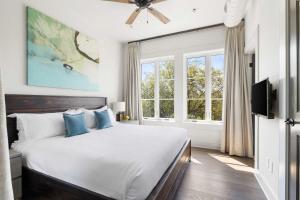 a bedroom with a large white bed with blue pillows at Fire Tower Luxe 2BR KingSuites & Private Balcony in Charleston