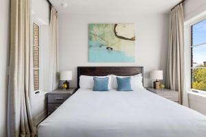 a bedroom with a large bed and two windows at Fire Tower Luxe 2BR KingSuites & Private Balcony in Charleston +10 photos