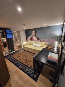 a living room with a couch and a painting of a woman at Snow Lodge Hotel Courchevel 1850 in Courchevel