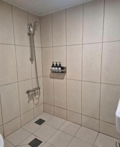 a bathroom with a shower with bottles on a shelf at 인천청라점 이상한스테이 